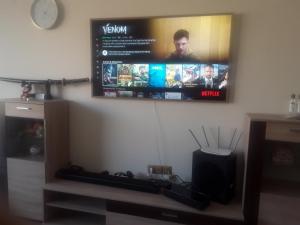 a flat screen tv hanging on a wall at Апартамент SUMI in Varna City +6 photos