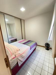 um quarto com uma cama e um espelho em Apt temporada guarapari em Guarapari