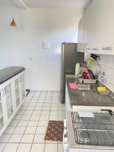 a kitchen with a sink and a stove in it at Apt temporada guarapari in Guarapari