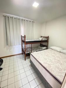 1 dormitorio con 2 camas y ventana en Apt temporada guarapari en Guarapari