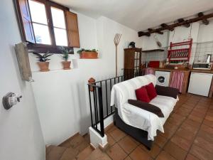 a living room with a white couch with red pillows at Casa Rural La Buhardilla in Benaocaz +6 photos