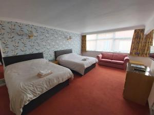 ein Hotelzimmer mit 2 Betten und einem Sofa in der Unterkunft The Highfield Hotel in Bradford