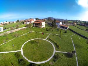 an aerial view of a large green field with a building at La Cochera de Somao, casona de tipología indiana in Somado
