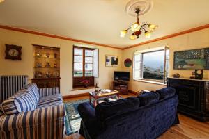 a living room with two couches and a fireplace at La Cochera de Somao, casona de tipología indiana in Somado