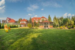a large yard with a large house in the background at Pensjonat Szczebel in Mszana Dolna