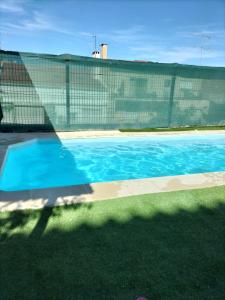 una piscina azul en un patio con una valla en Bem Me Quer, en Almada