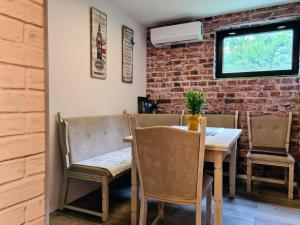 a dining room with a table and chairs and a brick wall at Happy Sparrow in Karlovac