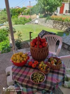 a table with baskets of fruits and vegetables on it at Villa The Cave in Blagaj