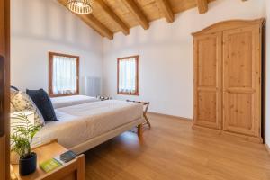 1 dormitorio con 1 cama y suelo de madera en Agriturismo Fondo Gioconda en Marcon