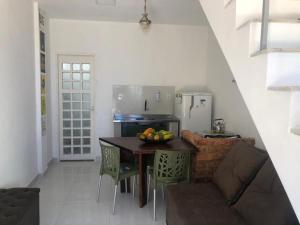 a small kitchen with a table and a refrigerator at Casalê in Lençóis