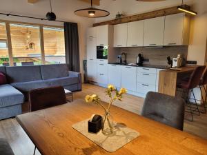 a kitchen and living room with a table and a couch at Alpen Quartier in Uderns