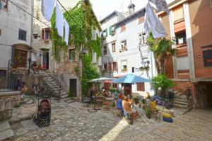 grupa ludzi siedzących przy stolikach w alejce w obiekcie Casale Piazzetta w Rovinj