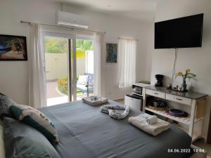 a bedroom with a large blue bed with a television at Las Palmas - New Horizon in Dixon Cove