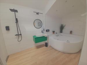a white bathroom with a tub and a mirror at Logis Hôtel La Chaize in Noirmoutier-en-l'lle