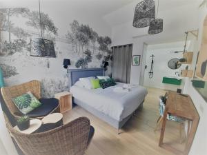a bedroom with a bed and a table and chairs at Logis Hôtel La Chaize in Noirmoutier-en-l'lle