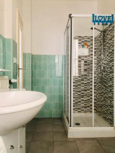 y baño con ducha, lavabo y bañera. en Peaceful apartment 1 minute walk to the beach, en Ventimiglia