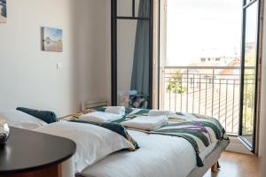 two beds in a room with a balcony at Down Center - Incroyable vue mer proche plage in Arcachon