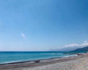 una playa con gente sentada en la arena y el océano en Peaceful apartment 1 minute walk to the beach, en Ventimiglia