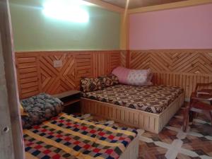 a room with two beds and a couch in it at MAA BHAGWATI HOME STAY in Kalpa