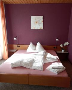 um quarto com uma cama grande e uma parede roxa em Hotel Restaurant Bad Gutenburg em Lotzwil