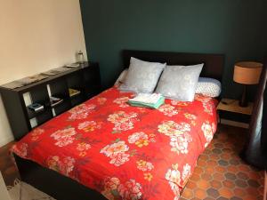 Una cama con un edredón rojo con dos libros. en Appartement Paris Marais, en París