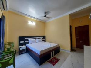a bedroom with a bed and a table and chairs at Blue Stone Hotel & Restaurant Mandarmani in Mandarmoni