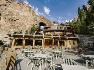 a restaurant with tables and chairs in front of a mountain at Famree Resort Hunza in Hunza Valley