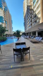 a row of benches and a table in a building at OLÍMPIA PARK RESORT O MAIS DIVERTIDO RESORT EM FRENTE AO THERMAS DOS LARANJAIS - PAGUE em ATÉ 12 VEZES in Olímpia
