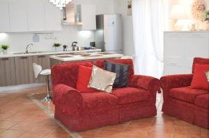 een woonkamer met 2 stoelen en een keuken bij La Rondine Holidays in Anguillara Sabazia