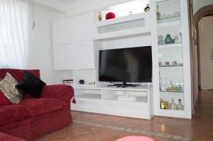 een woonkamer met een tv op een wit entertainmentcentrum bij La Rondine Holidays in Anguillara Sabazia