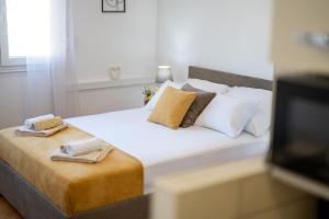 ein Schlafzimmer mit einem Bett mit zwei Handtüchern darauf in der Unterkunft Apartments Plokite in Split