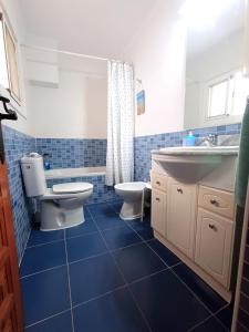 a blue bathroom with a toilet and a sink at Casa Ridao-Habitación Indalo con vistas in Mojácar