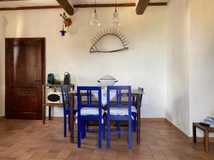 een eetkamer met blauwe stoelen en een tafel bij Panoramic Nest In Montalcino in Montalcino