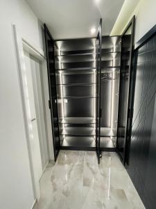 a walk in closet with black and stainless steel doors at Apartmani Mila in Laktaši