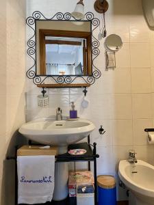 a bathroom with a sink and a mirror and a toilet at Panoramic Nest In Montalcino in Montalcino +33 photos