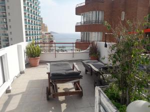a balcony with chairs and tables on a building at Apartamento Inlesa I in Benidorm