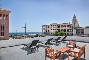 a row of chairs and tables on the roof of a building at Casa Pelayo in San Juan