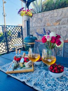 a table with two glasses of wine and food and flowers at Apartment Sonia in Ičići