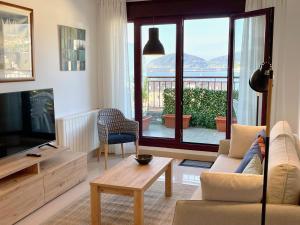 a living room with a couch and a television at The Cliffs - The Look Seiramar in Viveiro