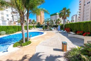 basen z palmami i budynkami w obiekcie INMOWEAVER 22B ES Con preciosas vistas al mar w mieście Calpe