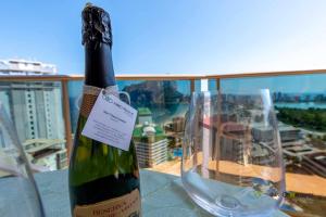 butelkę wina siedzącą obok szklanki w obiekcie INMOWEAVER 22B ES Con preciosas vistas al mar w mieście Calpe