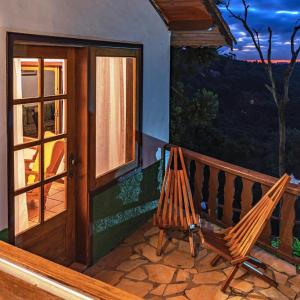 a porch with two chairs and a sliding glass door at Hotel Meissner Hof in Monte Verde