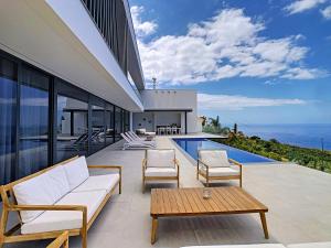 an outdoor patio with a view of the ocean at Heaven's Nest by LovelyStay in Ribeira Brava