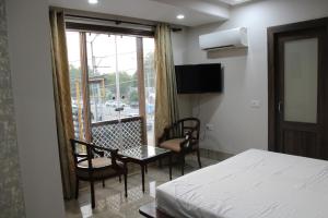 a hotel room with a bed and a table and chairs at Suryavilas in Ambāla
