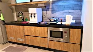 uma cozinha com um balcão e um micro-ondas em Limbongan Executive Suites Melaka By GGM em Malaca