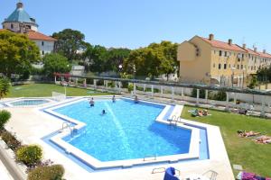 a large swimming pool with people in a yard at Algardia Marina Parque by Garvetur in Vilamoura