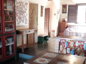 a room with a bed and a table in a room at Poente Guest House in Conceição da Ibitipoca