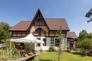 ein Haus mit einem weißen Regenschirm davor in der Unterkunft Penzion Kersko in Hradišťko