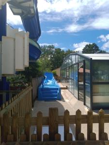 une maison en verre avec un toboggan bleu sur une terrasse dans l'établissement Mobil home 6 pers camping coeur de vendee, à Le Pont Legé