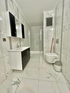 La salle de bains blanche est pourvue d'un lavabo et de toilettes. dans l'établissement Shahin Golden Hotel l الصقر الذهبي…, à Bostancı